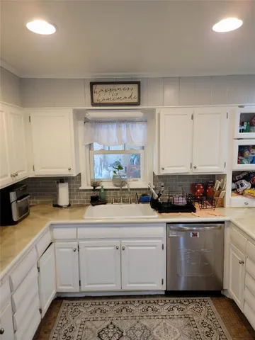 a kitchen with sink a stove and cabinets