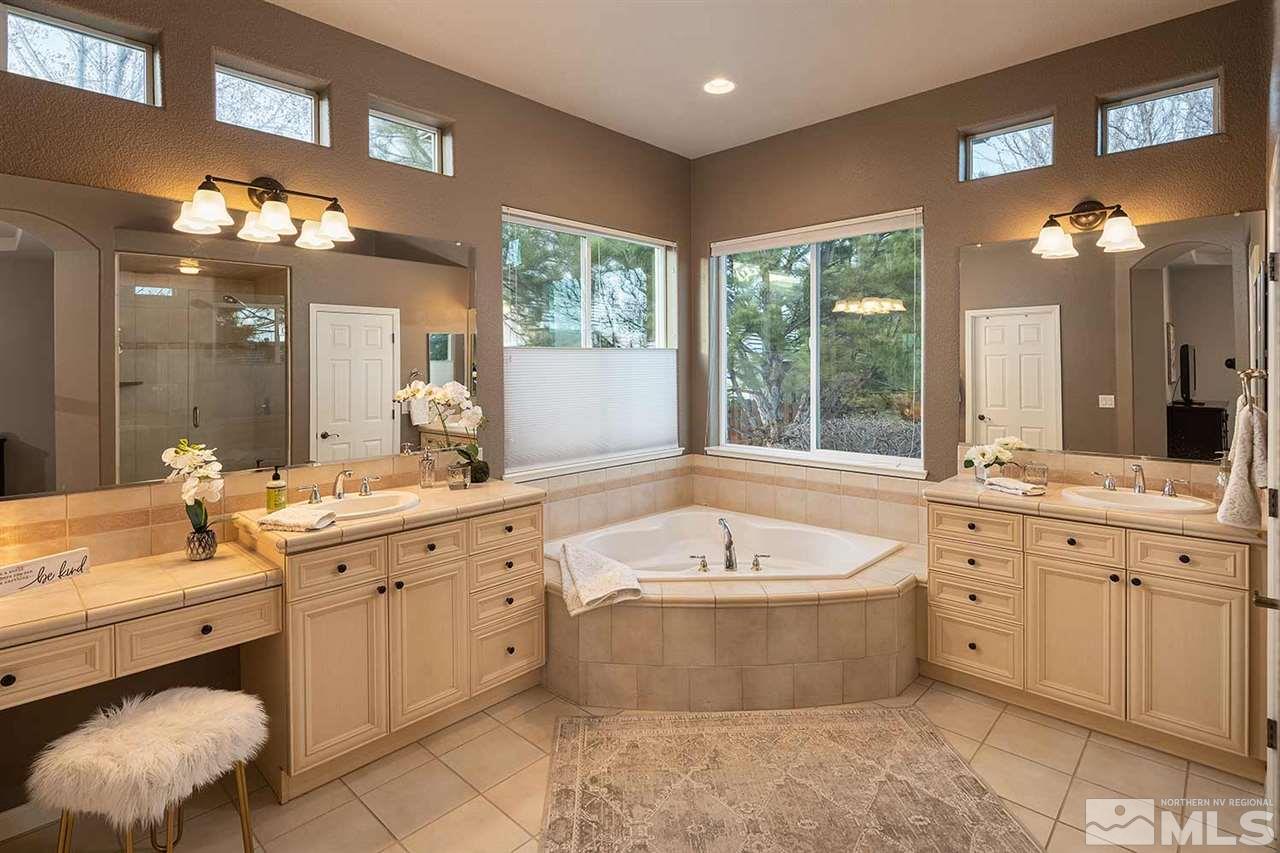 5278 North Elk River Road Reno, NV 89511 - Photo 23 of 30 a large spacious bathroom with a double vanity sink large mirror bathtub and next to a window