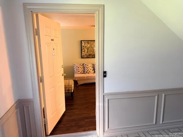 a view of a hallway with wooden floor and a livingroom