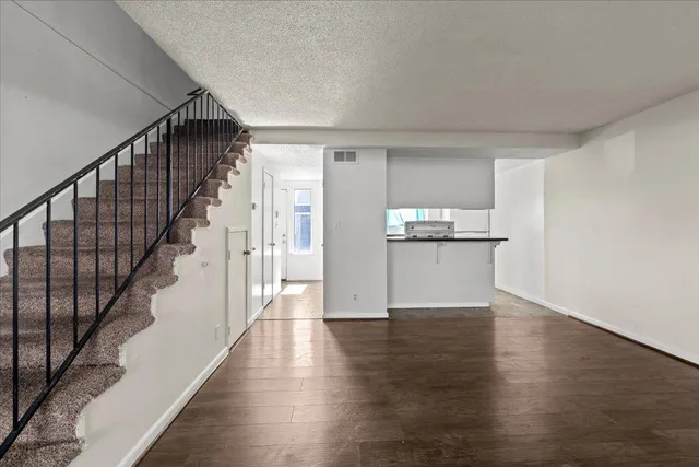 a view of a kitchen with wooden floor and electronic appliances