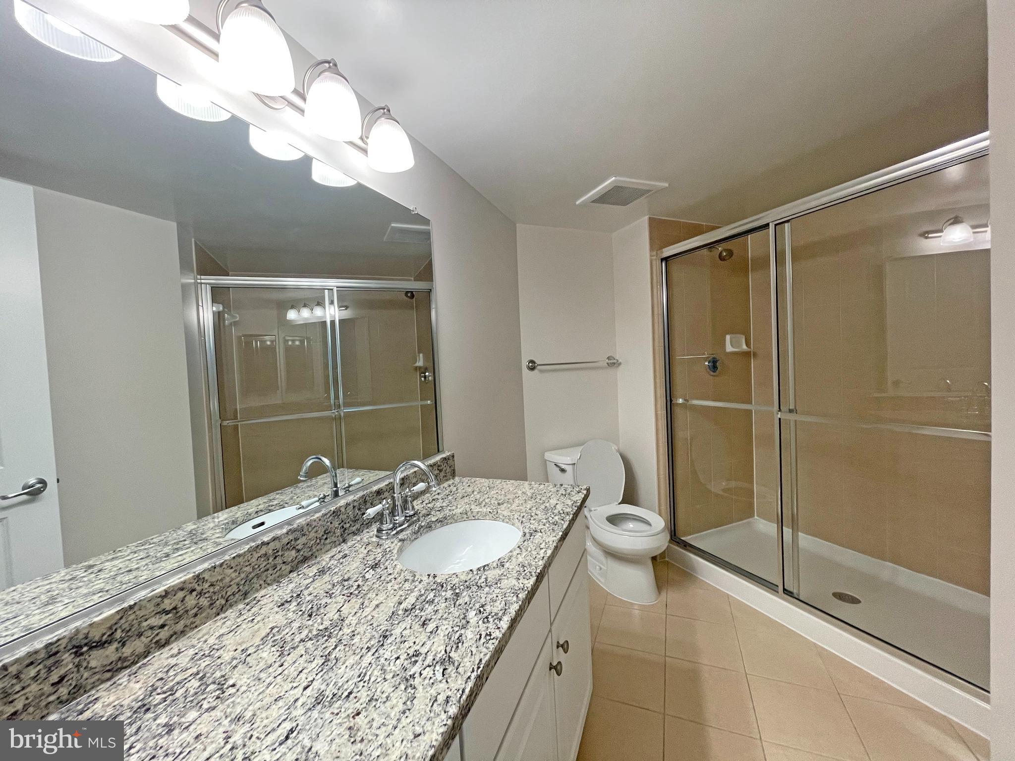 11800 Sunset Hills Road, Unit 722 Reston, VA 20190 - Photo 11 of 41 a bathroom with a granite countertop sink a toilet and shower