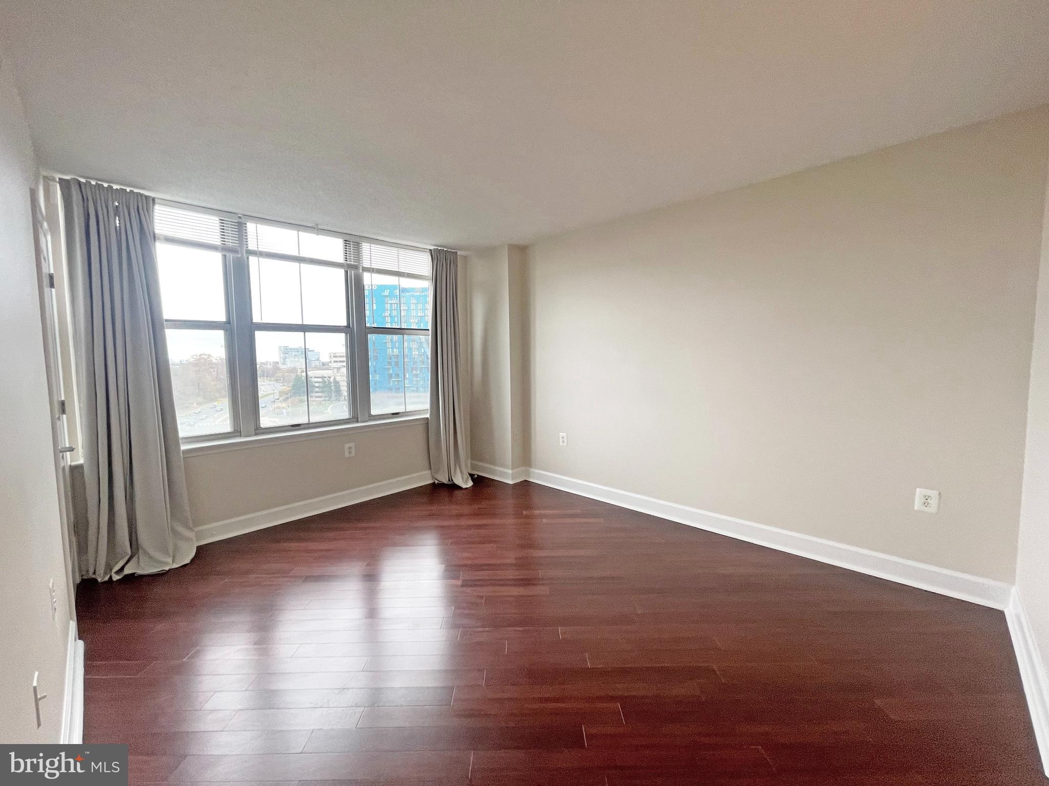 11800 Sunset Hills Road, Unit 722 Reston, VA 20190 - Photo 13 of 41 a view of an empty room with wooden floor and a window
