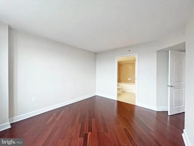 a view of a big room with wooden floor and windows