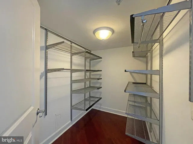a view of walk in closet with empty racks
