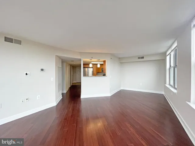 a view of a big room with wooden floor and windows