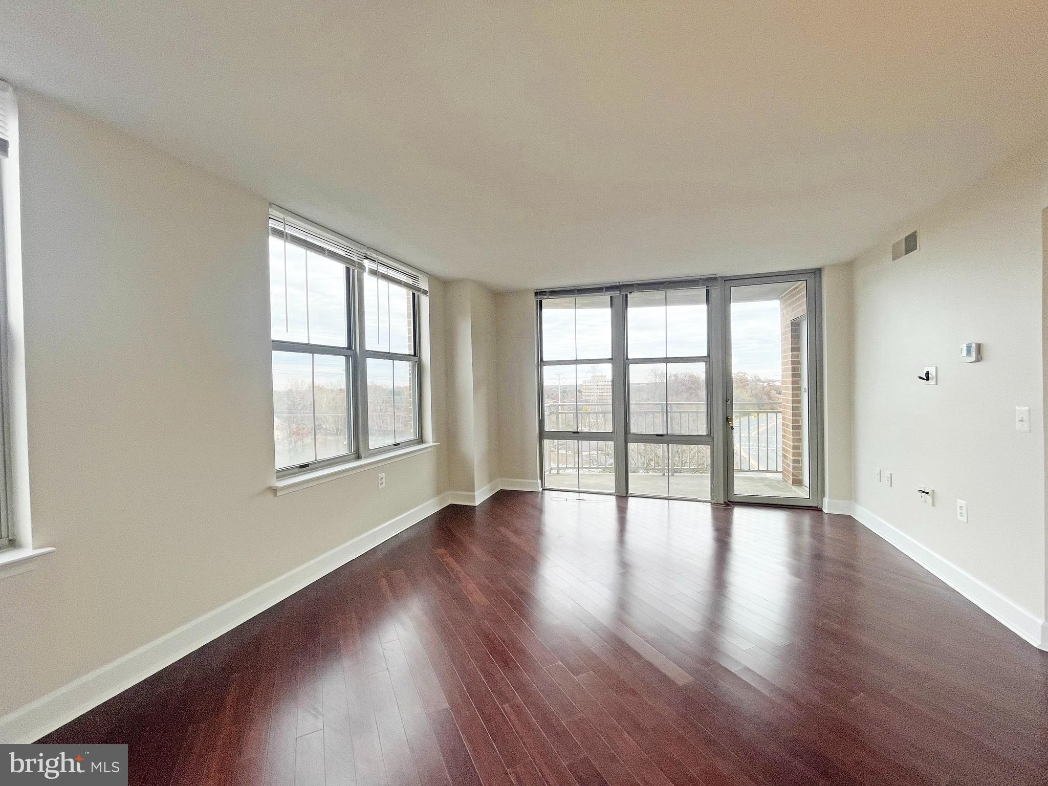 11800 Sunset Hills Road, Unit 722 Reston, VA 20190 - Photo 5 of 41 a view of an empty room with wooden floor and a window