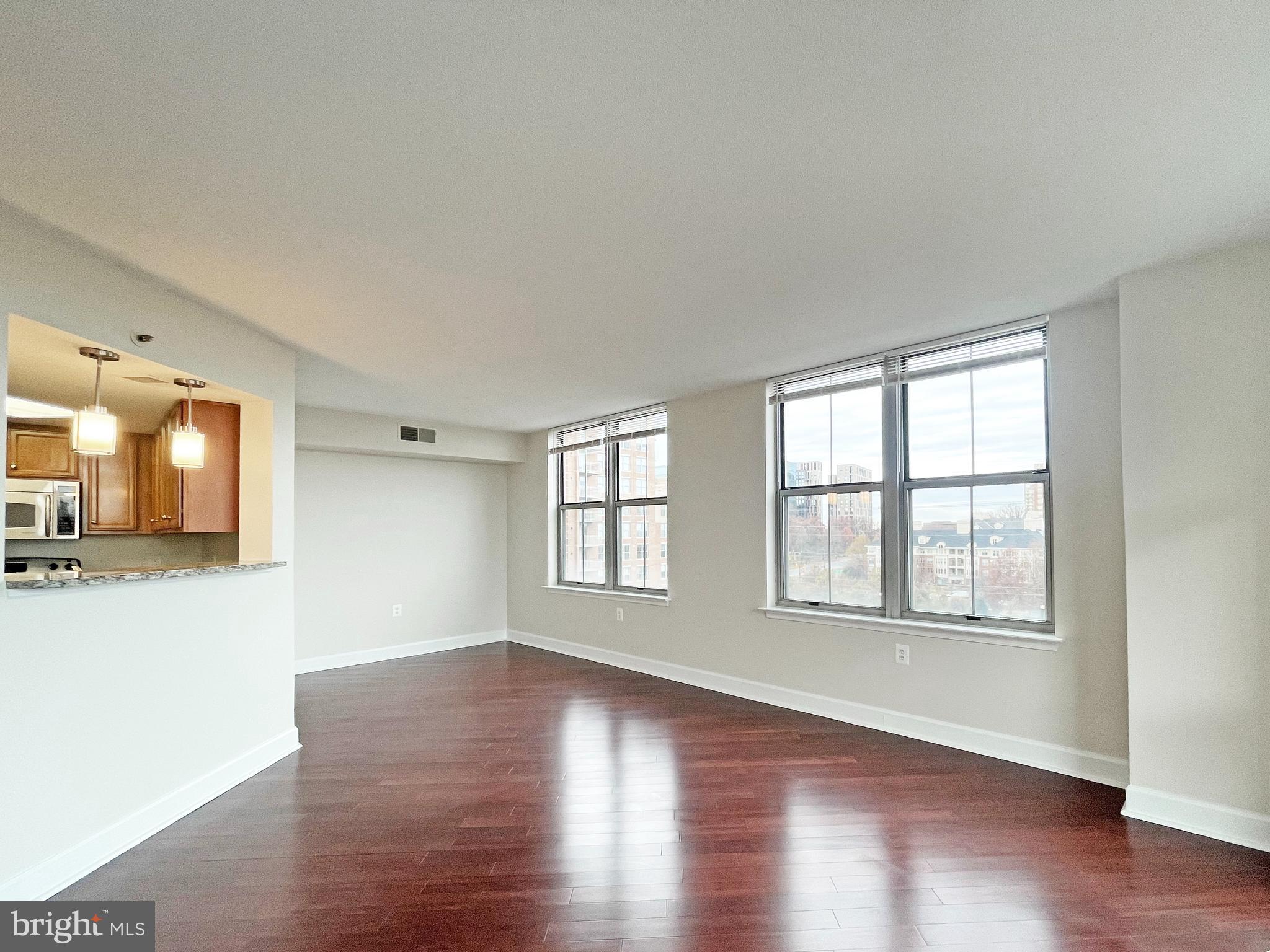 11800 Sunset Hills Road, Unit 722 Reston, VA 20190 - Photo 7 of 41 a view of an empty room with wooden floor and a window