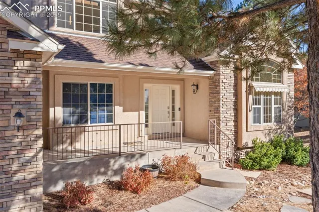 a front view of a house with a tree