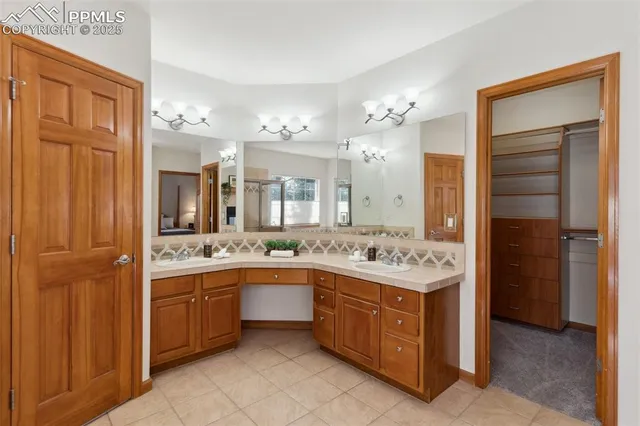a bathroom with a granite countertop double vanity sink a mirror and a bathtub