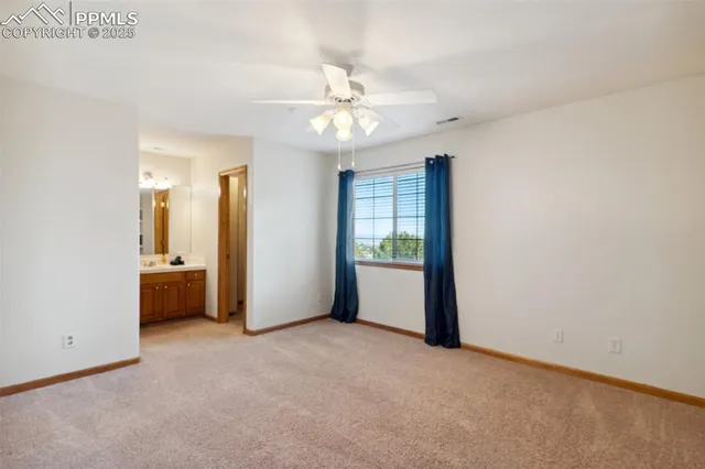 an empty room with fan and entrance