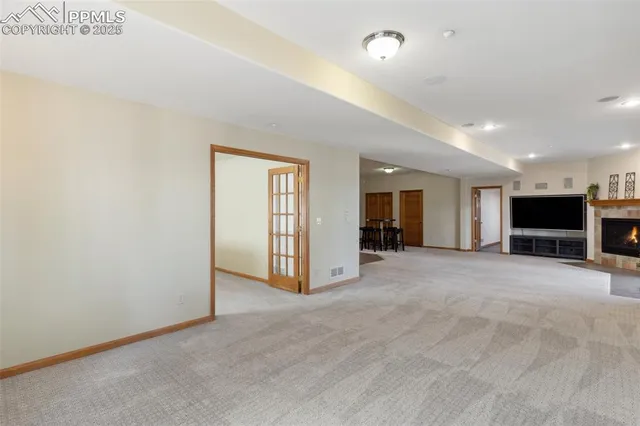 an empty room with a flat screen tv and fireplace