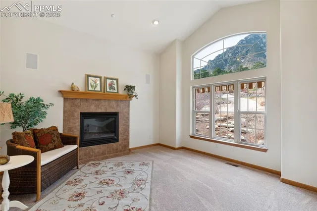 a living room with furniture a large window and a fireplace