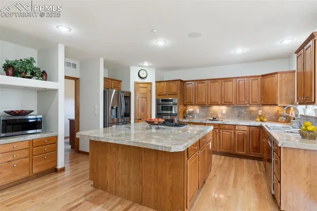 a kitchen with stainless steel appliances granite countertop sink stove top oven and cabinets