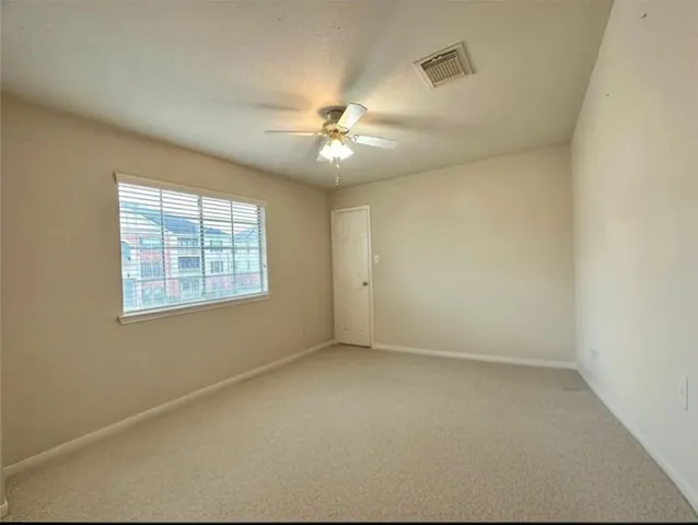 an empty room with a chandelier fan and a chandelier fan