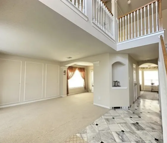 a view of a hallway with wooden floor and a living room
