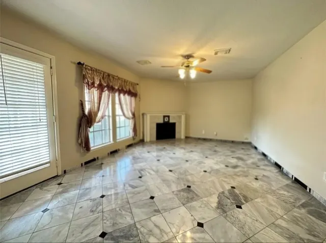 a view of a livingroom with a ceiling fan and window