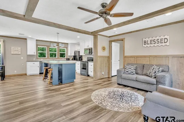 a living room with furniture and view of kitchen