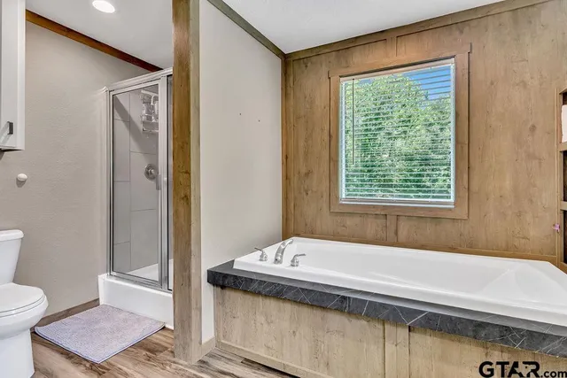 a bathroom with a granite countertop sink a toilet and shower