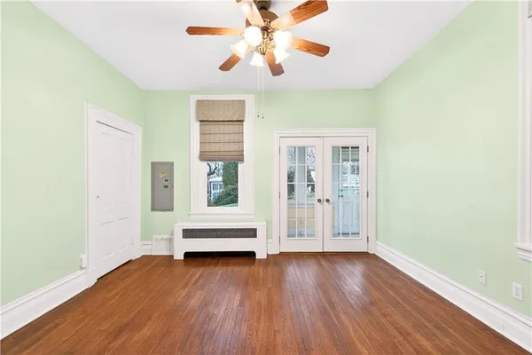 an empty room with wooden floor and windows