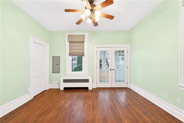 an empty room with wooden floor and windows