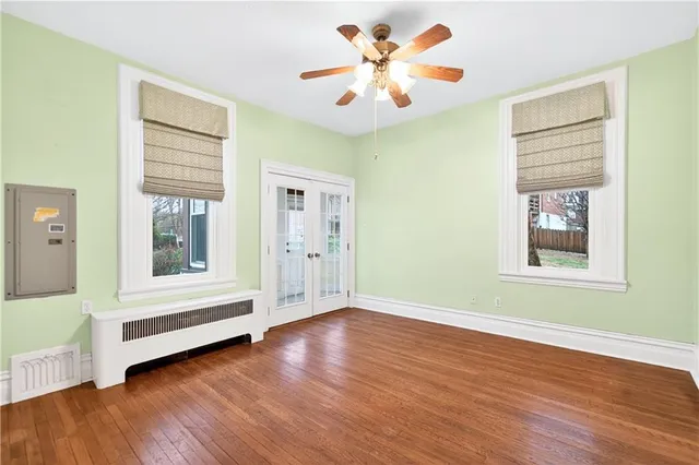 a view of an empty room with a window and wooden floor