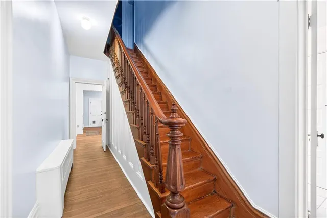 a view of a hallway with wooden floor and stairs