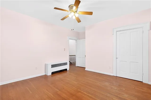 an empty room with a window and a ceiling fan
