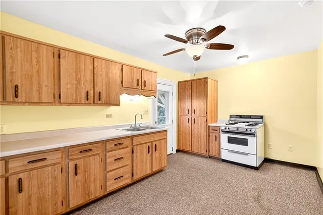 a kitchen with granite countertop a sink stainless steel appliances and cabinets
