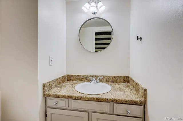 a bathroom with a granite countertop sink and a mirror