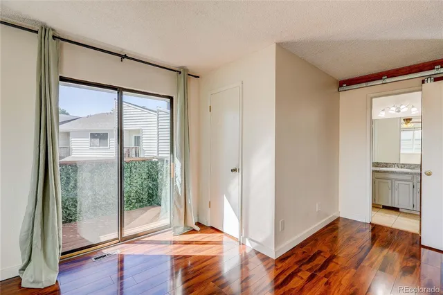 a view of an empty room and wooden floor and a window