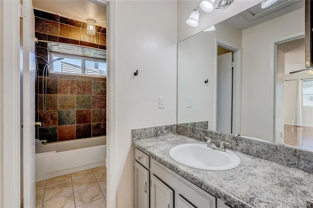 a bathroom with a granite countertop sink a mirror and shower