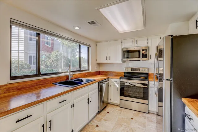 a kitchen with stainless steel appliances a stove sink and microwave