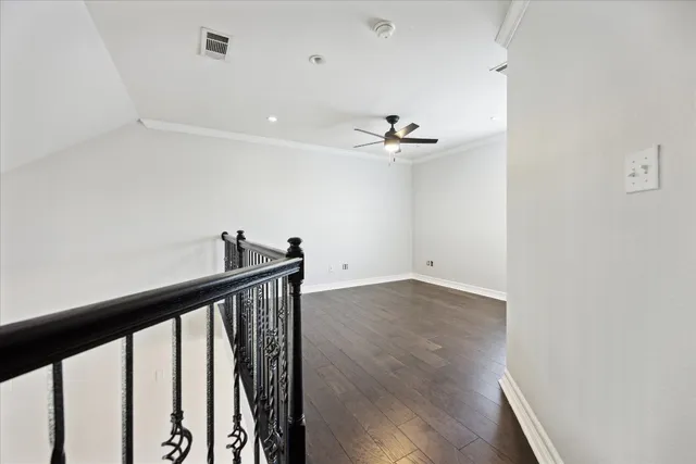 a view of a hallway with wooden floor and chandelier