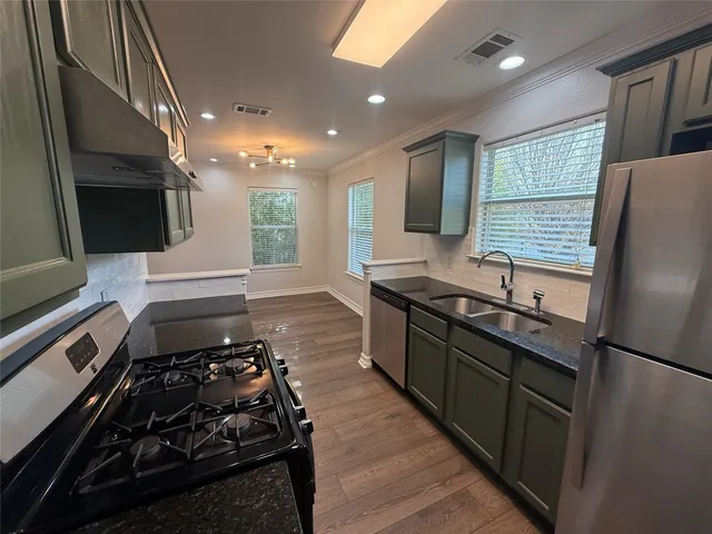 a kitchen with stainless steel appliances granite countertop a stove and a refrigerator