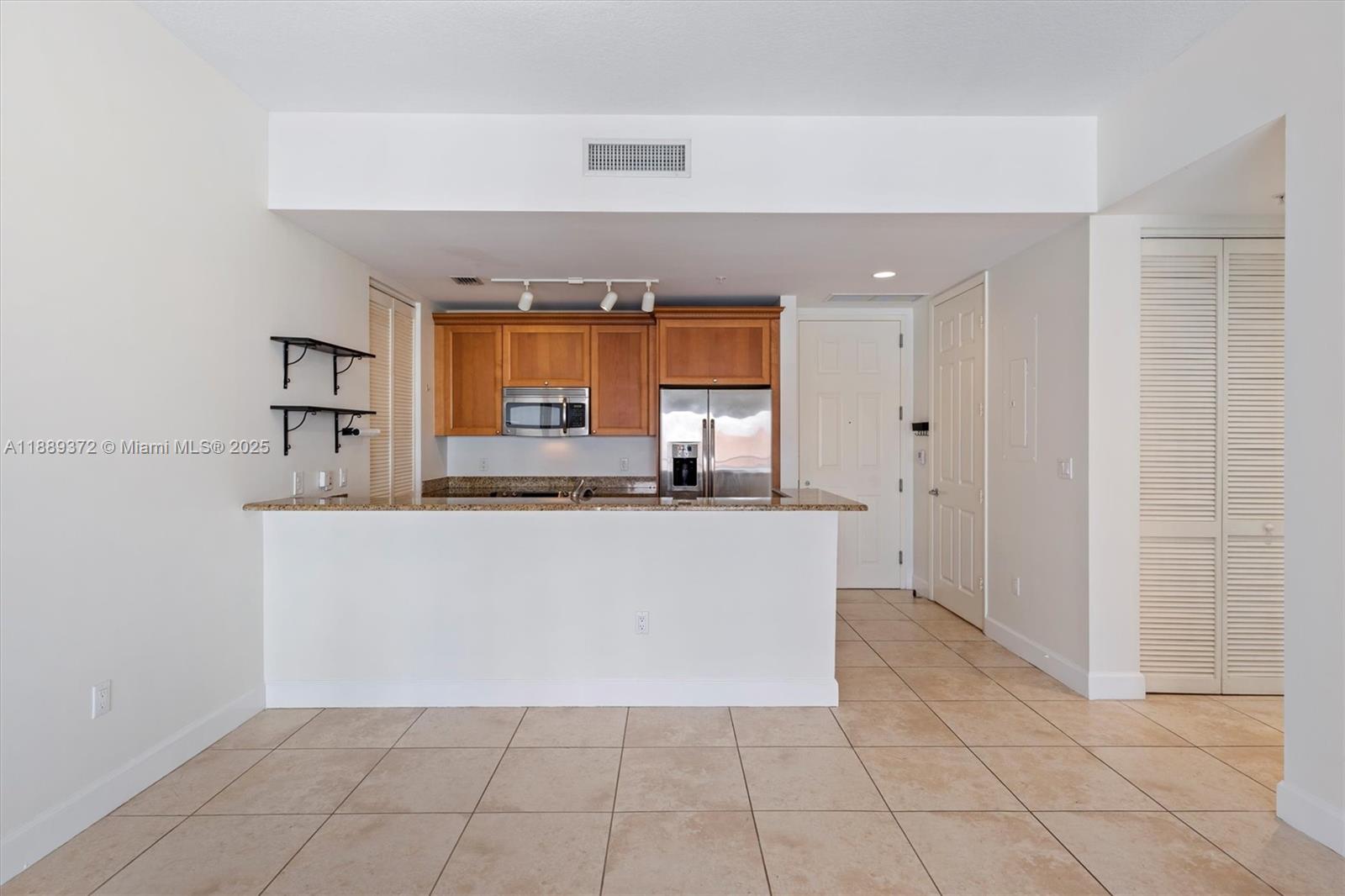 55 Merrick Way, Unit 814 Coral Gables, FL 33134 - Photo 32 of 39 a living room with stainless steel appliances kitchen island granite countertop a refrigerator and a stove top oven