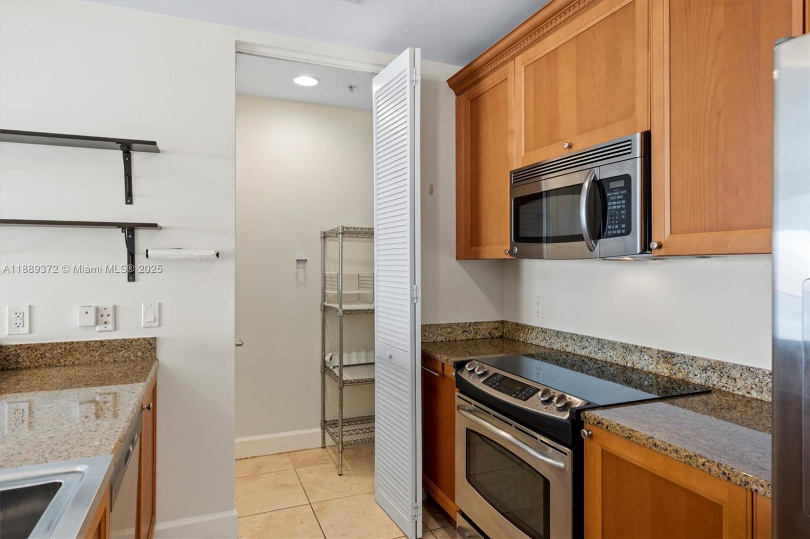 55 Merrick Way, Unit 814 Coral Gables, FL 33134 - Photo 5 of 39 a kitchen with a stove and a microwave