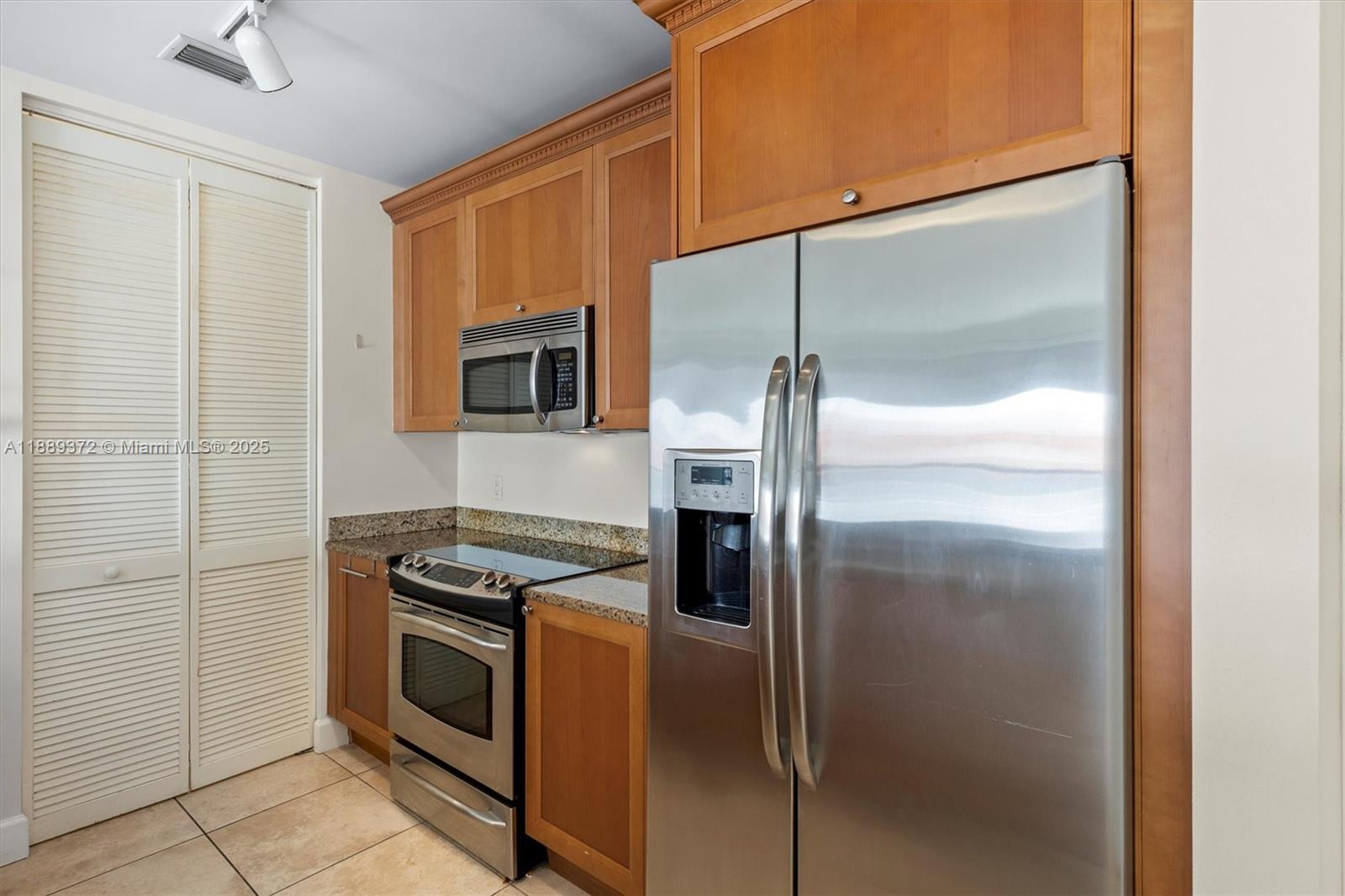 55 Merrick Way, Unit 814 Coral Gables, FL 33134 - Photo 6 of 39 a kitchen with a refrigerator a stove and a sink
