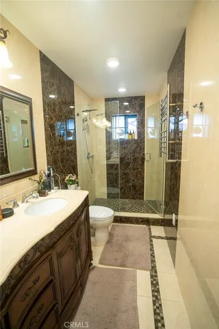 a bathroom with a double vanity sink toilet and shower