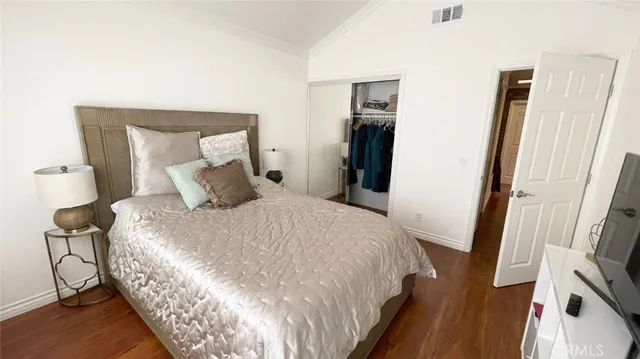 a bedroom with a bed and a flat tv screen on a dresser