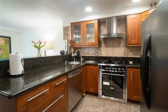 a kitchen with stainless steel appliances granite countertop a sink stove and refrigerator