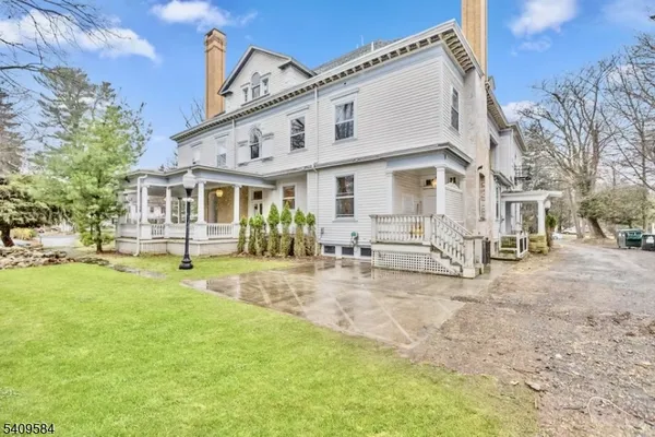 a view of a white house with a yard patio and a fire pit