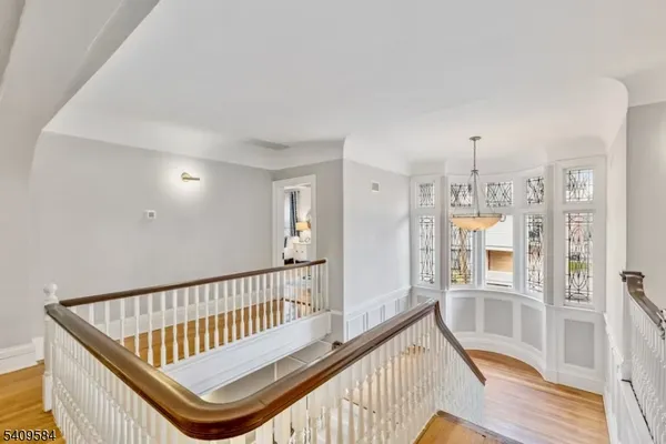 a view of a hallway with wooden floor and windows