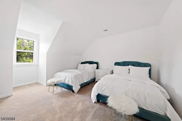 a bedroom with two bed and a window