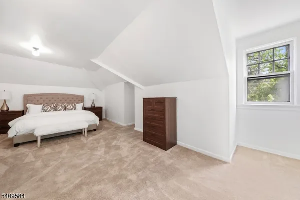 a spacious bedroom with a bed and a window