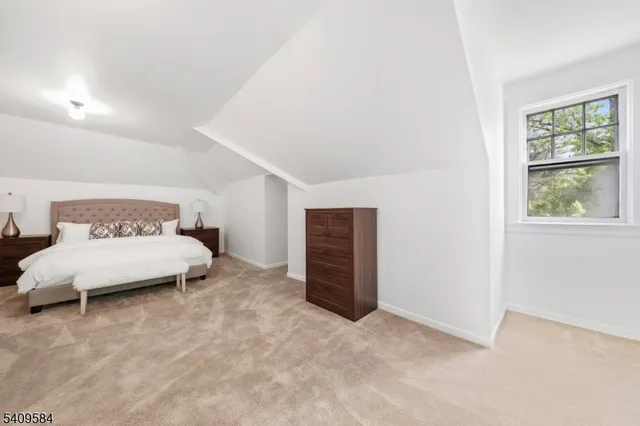 a spacious bedroom with a bed and a window