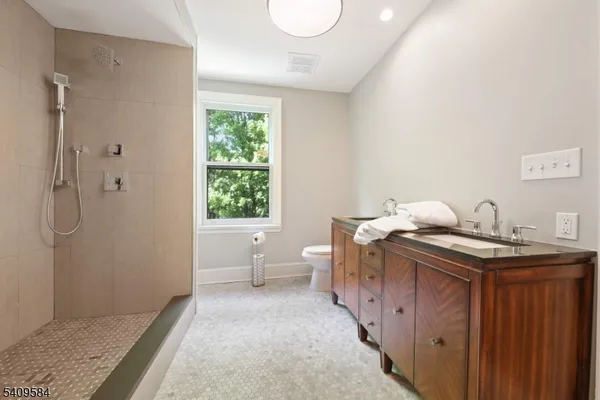 a bathroom with a granite countertop sink a toilet and shower