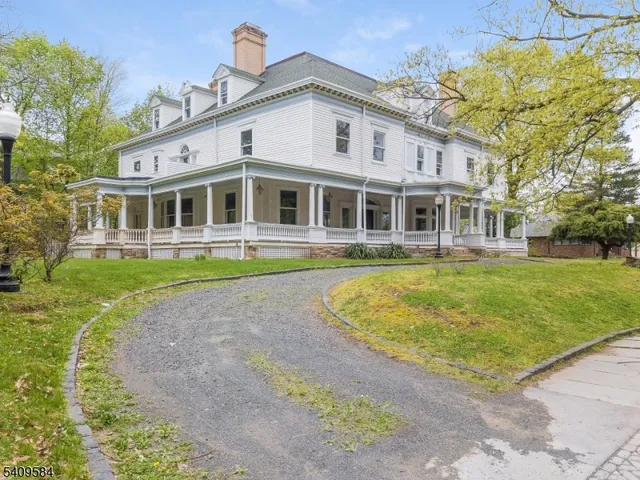 a front view of a house with a garden and trees