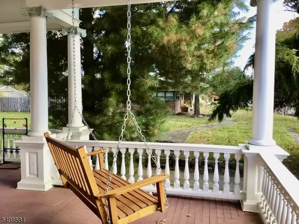 a view of a wooden chairs and bench in the porch
