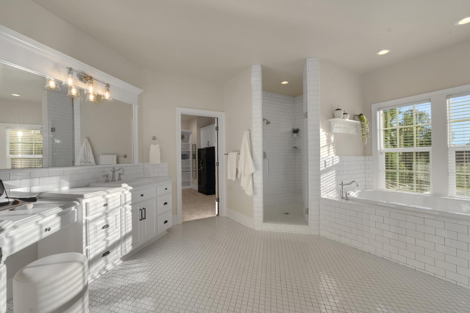 2905 Virginiatown Road Lincoln, CA 95648 - Photo 28 of 86 Spacious bathroom featuring white penny tile flooring, a dual vanity with a built-in makeup counter, a walk-in shower with subway tile, a soaking tub, and multiple windows with blinds