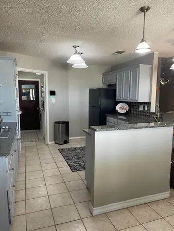 a view of a kitchen with a sink and a refrigerator